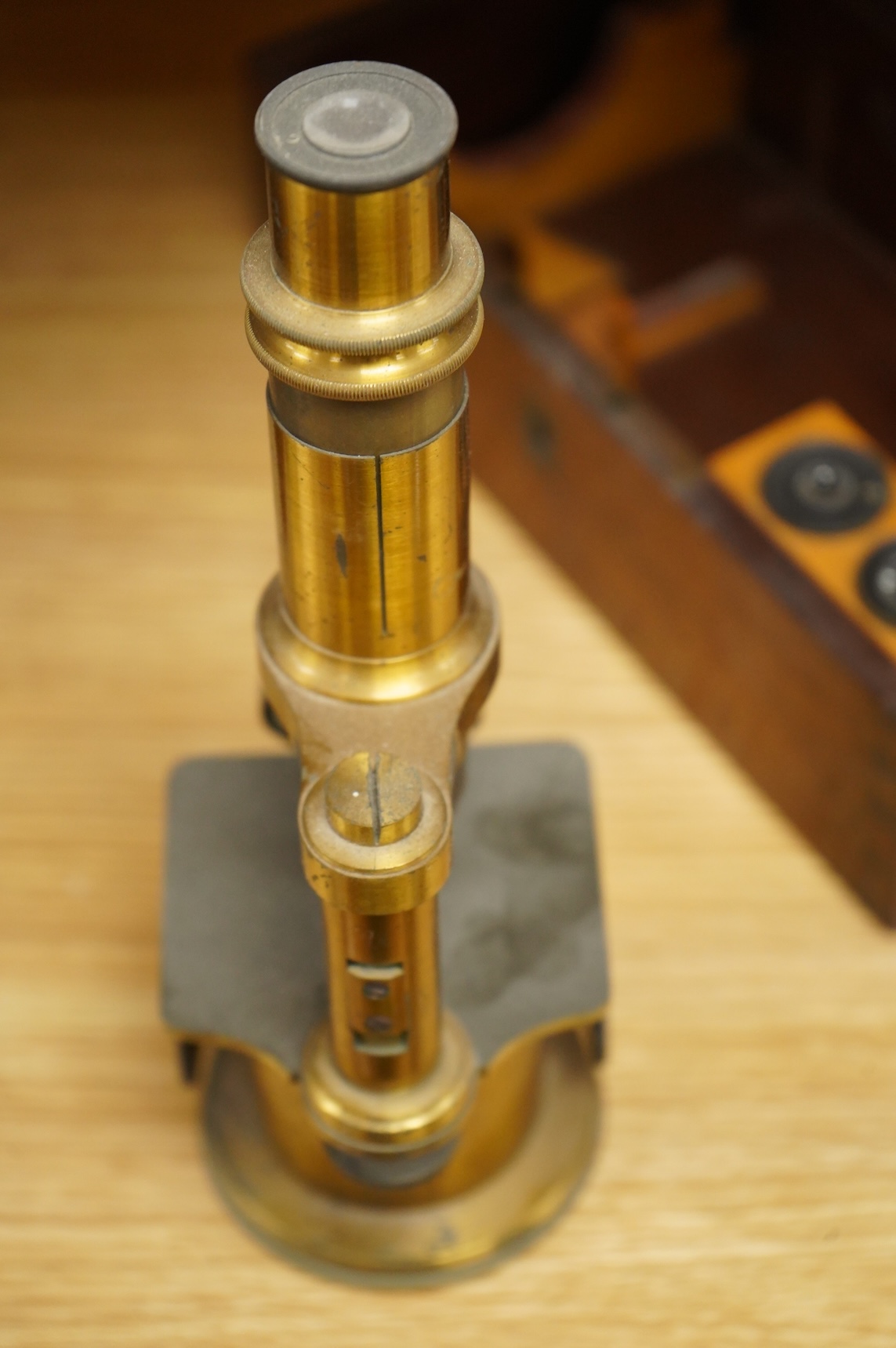 A mid 19th century French brass compound monocular microscope, by Nachet, Optician, Rue Serpente 16, Paris, with two eyepieces, three objectives and several slides, mahogany cased, instrument height 23cm